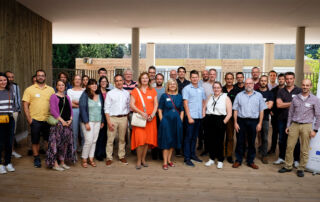 Group photo of kick off meeting participants. There is HelEx project rollup on their left side.